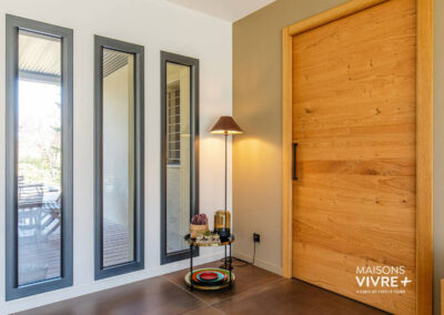 Hall avec grande porte d'entrée et vitrages chassis verticaux